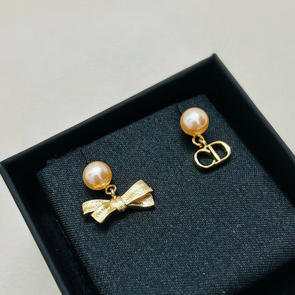 CD 26S PEARL BOW MISMATCH DROP EARRINGS IN GOLD TONE METAL 646611